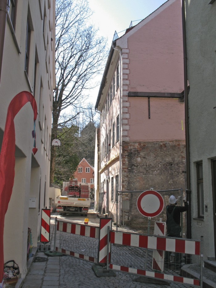 Blick in das Kaisergäßchen, auf der rechten Seite eine Lücke eines abgerissenen Hauses, dahinter das alte Museumsgebäude, im Vordergrund eine Absperrung mit einem " Durchfahrt verboten"-Schild