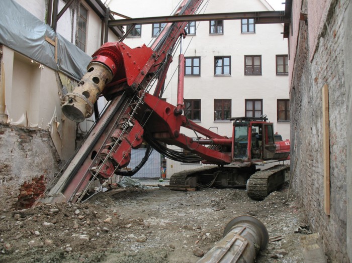 Eine riesige Baumaschine zwischen zwei Häuser auf der Museumsbaustelle