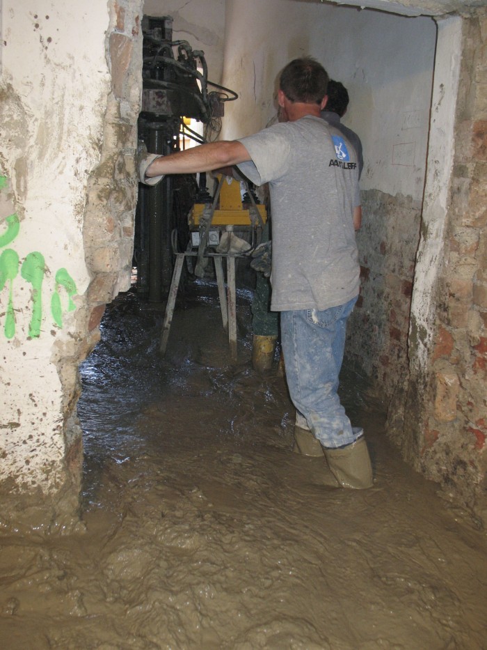 zwei Männer auf der Baustelle das alten Museumsgebäudes stehen in einem See aus Zement